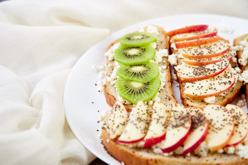 Healthy breakfast toasts with kiwi, apple, cottage cheese and chia seeds