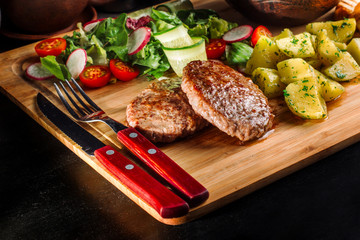 Lunch with fried meatballs, soup with meat and potatoes on a rustic.