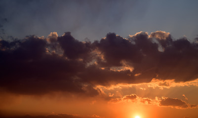 Dramatic sunset sky with orange clouds.