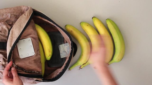 fast speed hands taking unpackaged fresh fruits out of old-school backpack after shopping. Zero waste, vegan, environmentally friendly and alternative lifestyle concept.