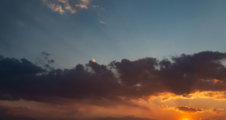 Dramatic sunset sky with orange clouds.
