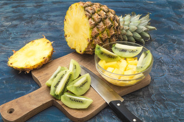 Delicious and healthy kiwi and pineapple fruit on old rustic desk