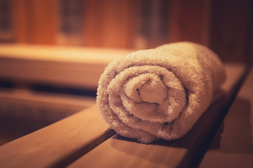 A close up of a soft terry bath towel in a wooden steam sauna. Comfortable rest in a traditional...