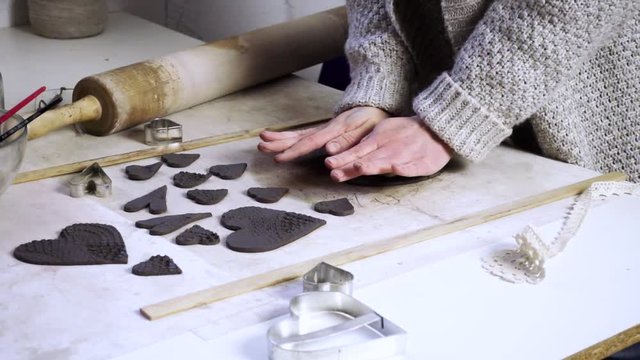 Woman decorating clay shapes, making a decorations