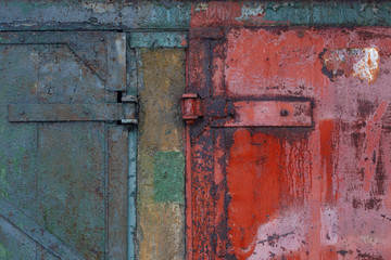 Fragment of old rusty gate with door hinges.
