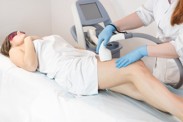 Obraz premium The process of laser depilation of female limbs in the beauty salon.