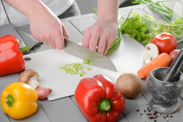 Skilled man chopping spring onion