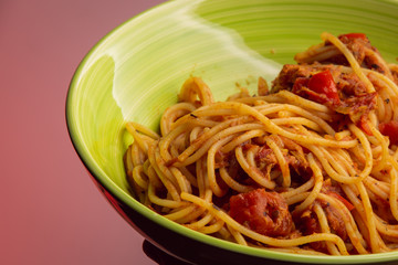 Green bowl of spaghetti with tomato sauce