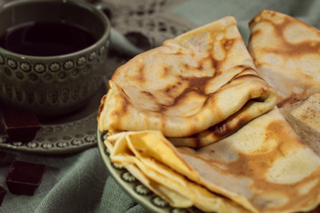 Cooked crepes folded on a plate with jam and apples
