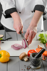 Chef cutting a red onion