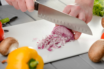 Man chopping a red onion