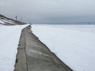 Concrete wall of the embankment against the background of the Russian winter landscape