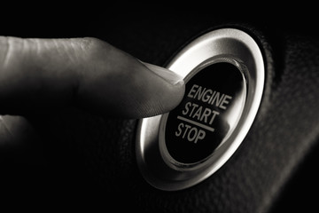 Finger pressing botton start or stop car engine