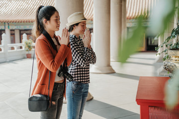 asian girls travelers pray at Buddhist temple during Chinese New Year celebration in Ho Chi Minh...