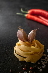 raw fettuccine paste with garlic cloves, chili oven and spices