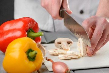 Chef slicing champignon mushrooms