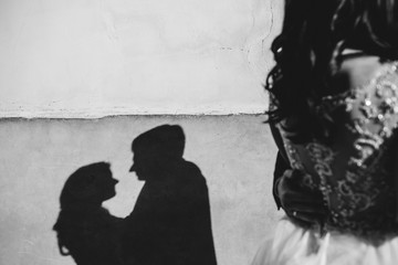 Couple love hug. Silhouette shadow on concrete wall.