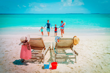 Fototapeta na wymiar mom, dad with kids have fun on beach vacation, family at sea