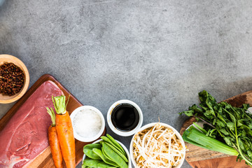 Raw uncooked poultry meat cut. Duck breast with vegetables, spices, wok ingredients on grey background, top view, copy space. horizontal.