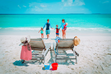 mom, dad with kids have fun on beach vacation, family at sea