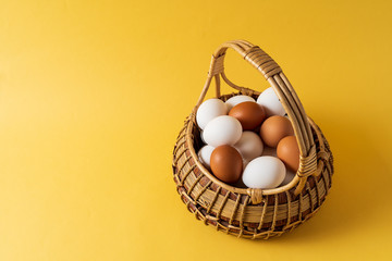 Eggs in a basket over yellow background.