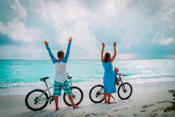 Fototapeta premium happy family with little baby biking on beach