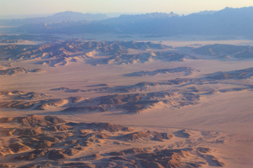 Fototapeta na wymiar Aerial view of Arabian desert and mountain range Red Sea Hills near Hurghada, Egypt. View from airplane