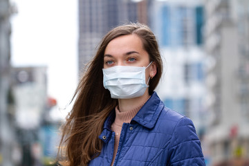 Woman in medical mask on street. Protection against virus, infection, exhaust and industrial emissions in urban. Air pollution and epidemic in city