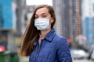 Woman in medical mask on street. Protection against virus, infection, exhaust and industrial emissions in urban. Air pollution and epidemic in city