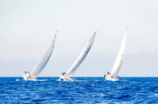 Tres barcos veleros en regata