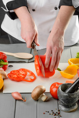 Chef cook slicing a pepper