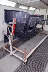 Vertical view of painting in red and black color of the inside of the frame of the car disassembled...