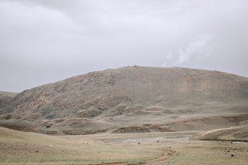 a scene of beautiful and majestic mountainous mountains against the background of a cloudy sky with...