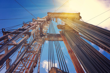 Onshore land rig in oil and gas industry. Oil drilling rig against a blue sky with clouds