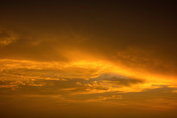 The golden light of the sun and clouds in the sky.
