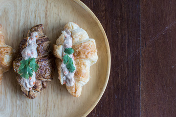 Croissant with Tuna Salad  Sandwich on wood table