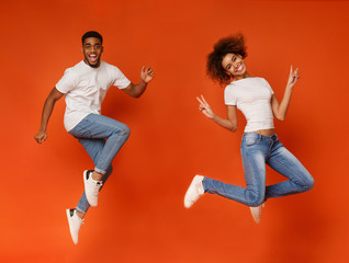 Cheerful african-american guy and girl running in air