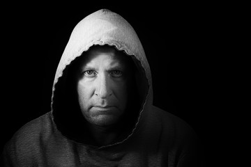 Dark and moody portrait of man in hoodie. Black and White image.
