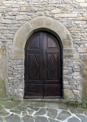 Antique wooden door with rock wall