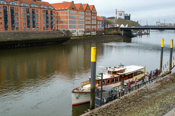 Fototapeta premium Pier with moored vessel on the banks of the River Weser in Bremen, Germany. March 2019