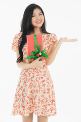 Curious woman in red dress rejoicing her birthday or new year gift box. Young woman holding gift  box with red bow being excited and surprised  holiday present isolated white  background