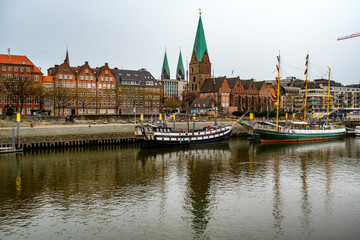 Alexander von Humboldt tall ship and others wooden sailing ships and barg floating on the banks of the River Weser.  St. Martini church on the background. Bremen, Germany. March 2019