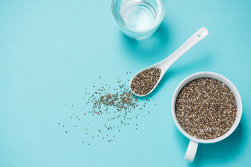 Glass of water and healthy chia seeds in a spoon. Text space.