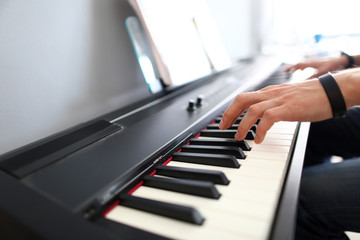 Male musician hands playing modern electric piano