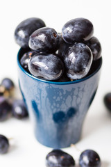Black grapes without seeds in a blue cup