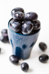 Black grapes without seeds in a blue cup