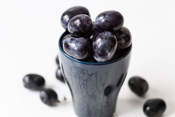 Black grapes without seeds in a blue cup