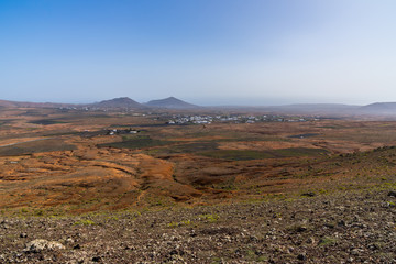 Spain, Lanzarote, Volcanic nature landscape and houses next to mountains