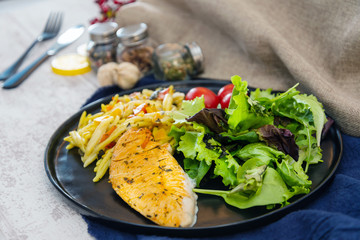 close-up of plate of pasta and chicken with lettuce