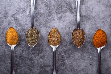 Spices in a spoon. Table with different spices. Various spices spoons